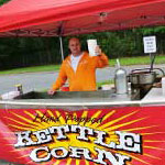 A man posing with his rental kettle corn cart in the Boston area