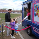 A child being served ice cream from an Ice Scream Social rental ice cream truck at a birthday party in Boston