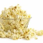 Popcorn overflowing from a glass bowl.