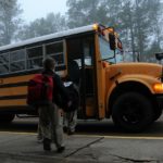 kids boarding school bus for first day back to school